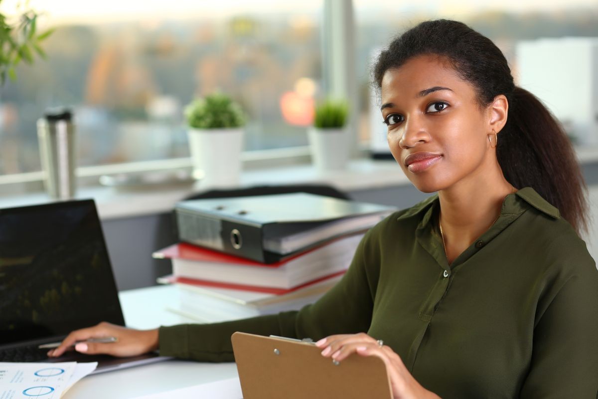 Beautiful black smiling businesswoman portrait at workplace look in camera. White collar worker at workspace exchange market job offer certified public accountant internal revenue officer concept